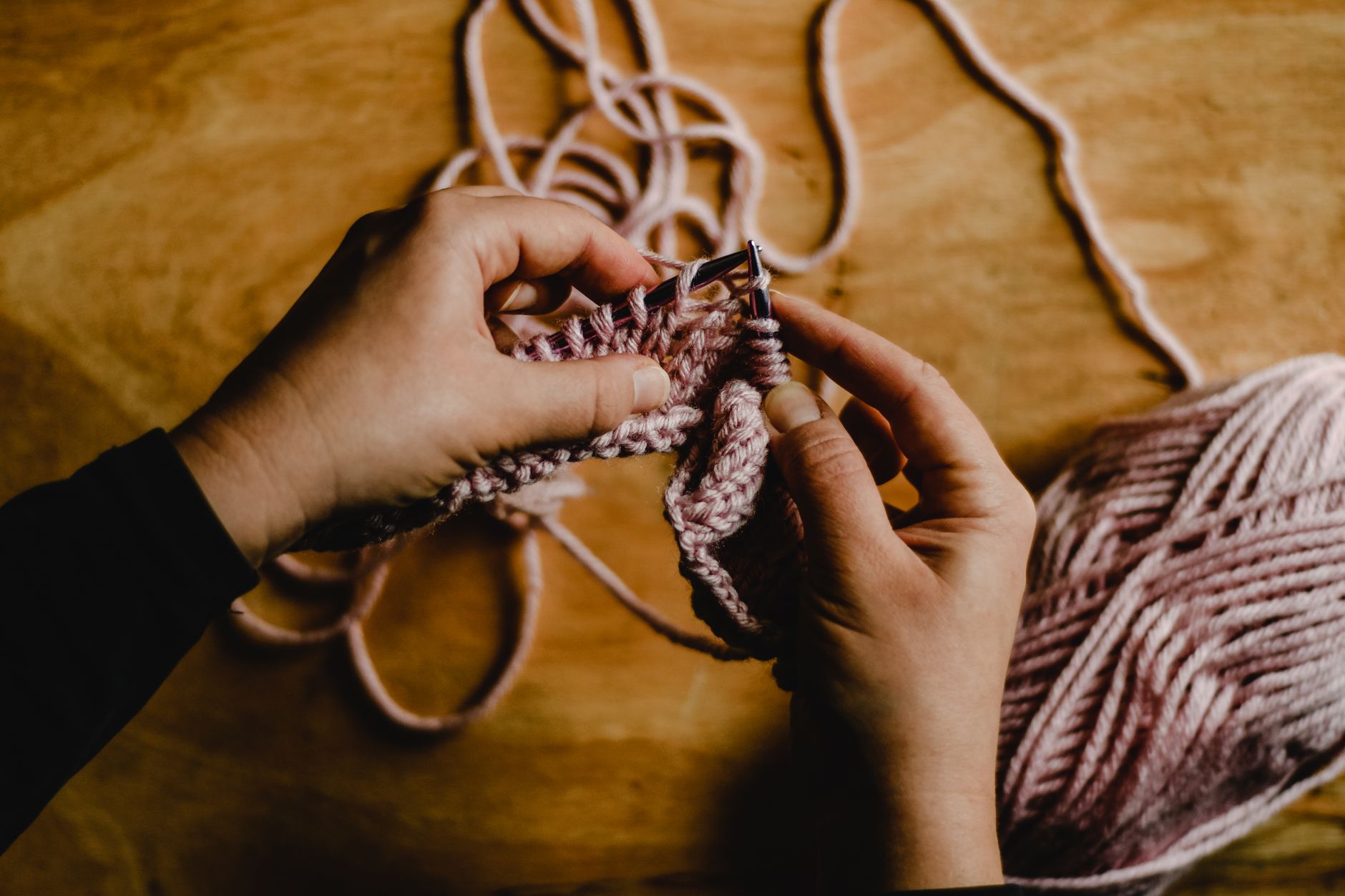 Méthodes pour apprendre le tricot: choisir le bon format pour progresser — mains avec aiguilles et laine
